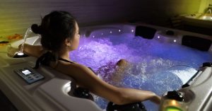 Individual experiencing the soothing effects of hydrotherapy jets in a hot tub.