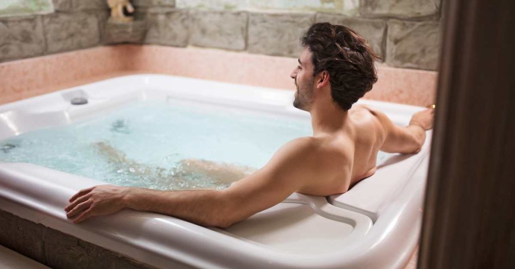 Hiker soaking in hot tub at sunset desert for recovery