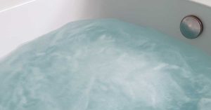 Clear bathtub swirling water with cloudiness visible