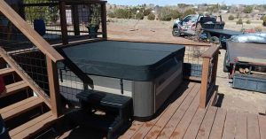 Durable hot tub cover installed on outdoor spa with lifter system