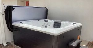 Hot tub with hydraulic cover lift installed for easy backyard spa access