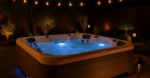 image of backyard hot tub at night with integrated outdoor lighting including string lights and LED pathway lights