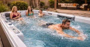 Family enjoying a swim spa in a Goodyear backyard with both relaxation seating and swim area