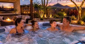 Family relaxing together in a premium hot tub with hydrotherapy jets in a Mesa Arizona backyard