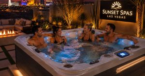 Friends enjoying a Luxury energy-efficient hot tub installed in a modern Las Vegas backyard at sunset