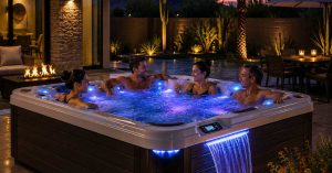 Friends while enjoying a luxury energy-efficient hot tub with LED lighting and waterfall feature installed in a modern Chandler backyard