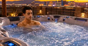 Las Vegas homeowner relaxing in a premium outdoor hot tub at sunset while using adjustable hydrotherapy jets
