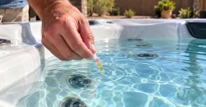 Chandler homeowner checking clear hot tub water and testing spa water chemistry during routine backyard maintenance